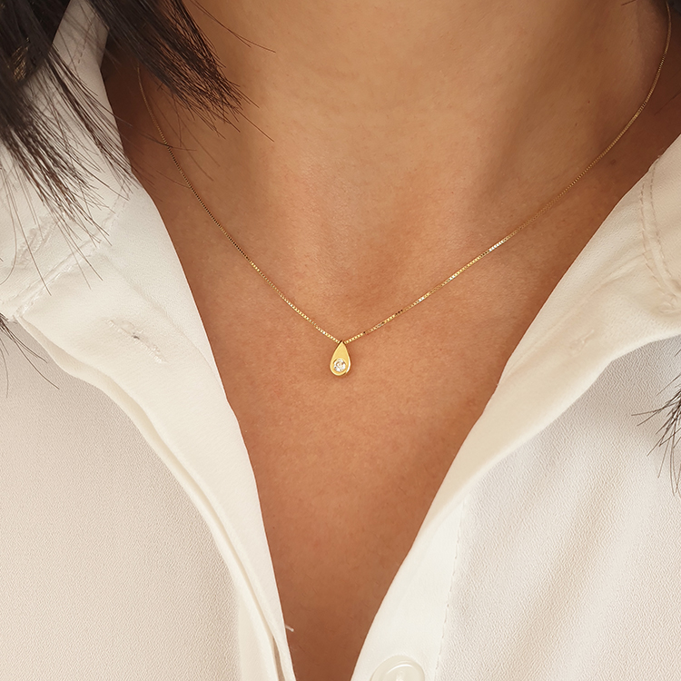 Realistic picture of A drop-shaped gold pendant set with a real diamond