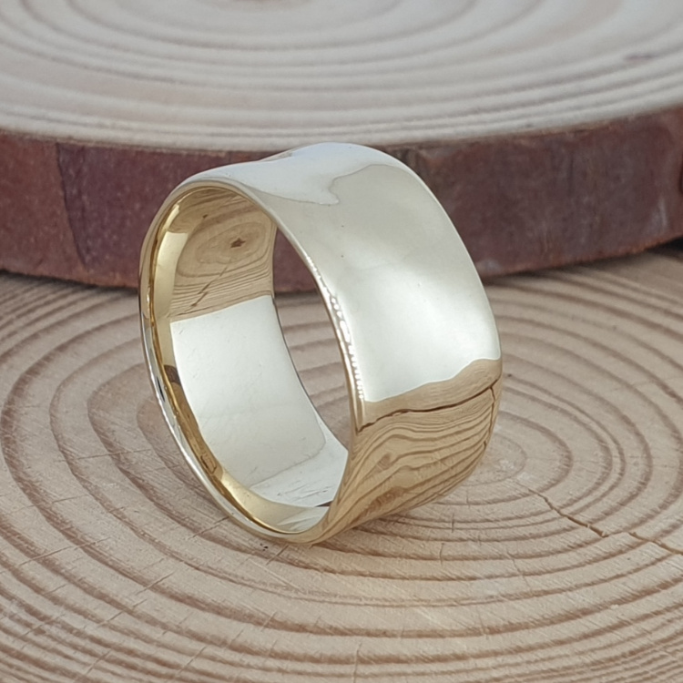 Realistic picture of A wide and slightly hammered wedding ring