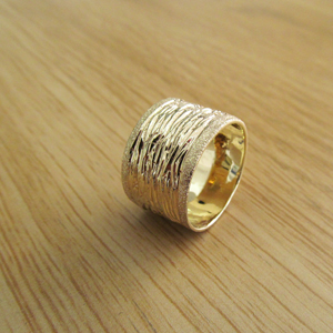 Realistic picture of 14k gold wide wedding ring with special textures